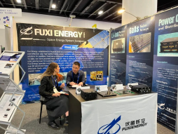 Seated discussion at a Fuxi booth table with power-system samples.
