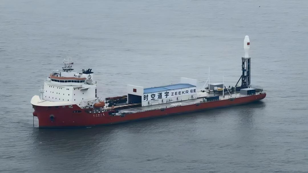 Offshore launch vessel carrying an upright rocket before launch.