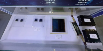 Solar-cell samples and black power-system units in a glass display case.
