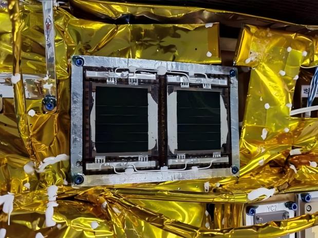 Two dark solar-cell samples mounted side by side on gold thermal insulation.