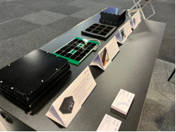 Tabletop display of solar-cell samples and power units with product labels.